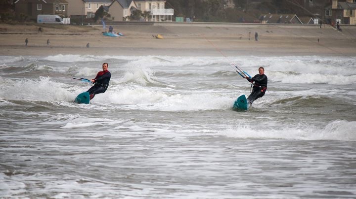 Two people kitesurfing